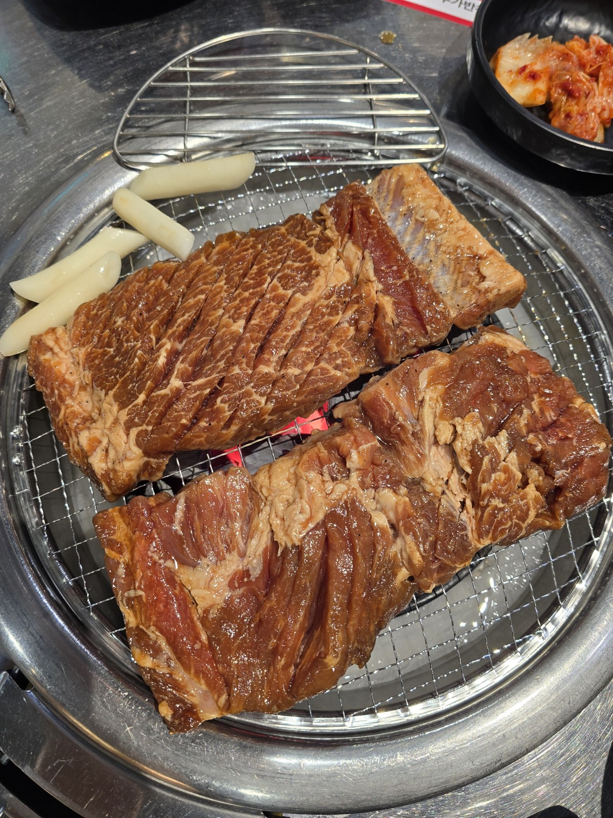 춘천 돼지갈비를 숯불에 올린 모습과 떡