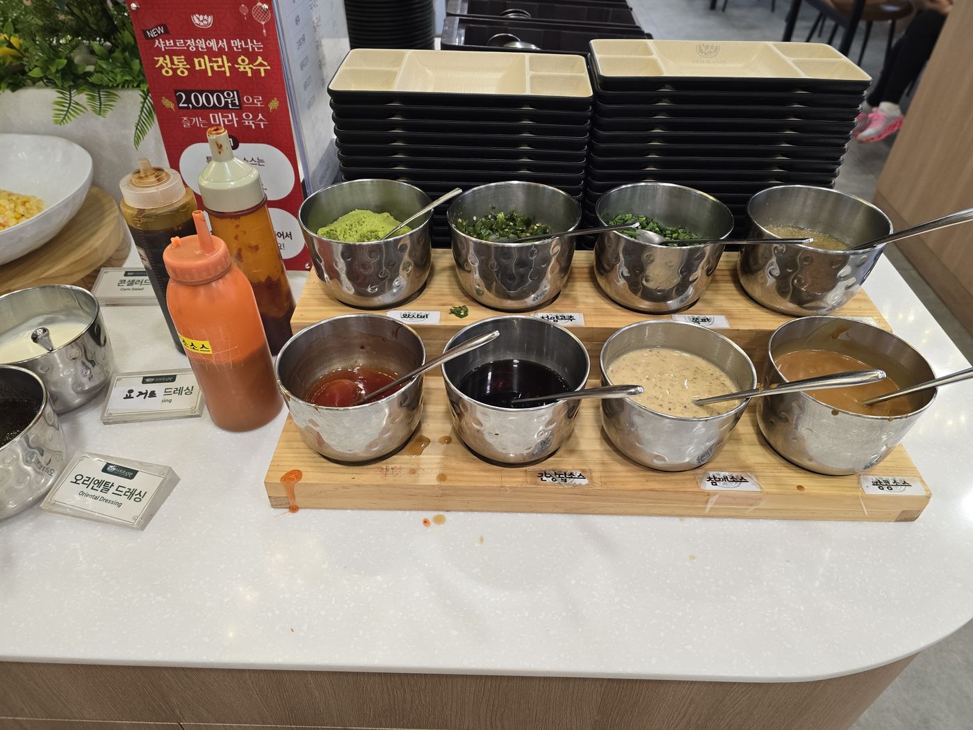 와사비, 청양고추, 쪽파, 간장딥소스, 참깨소스, 땅콩소스가 담긴 스테인리스 소스 그릇