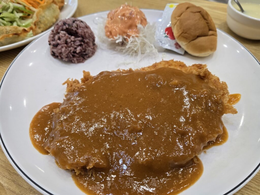 소스가 끼얹어진 치킨까스와 흑미밥, 모닝빵