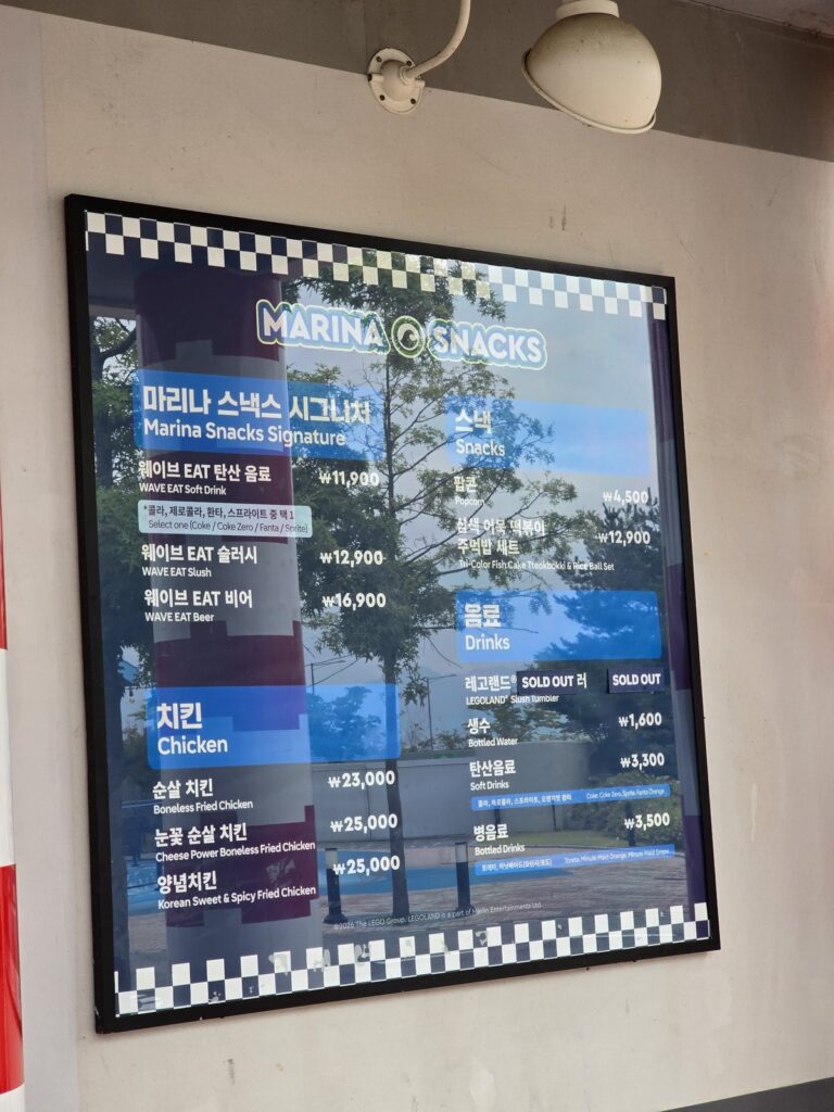 마리나 스낵스 벽면 메뉴판 — 웨이브 EAT 3종과 치킨 3종, 스낵, 음료 가격이 적혀 있다