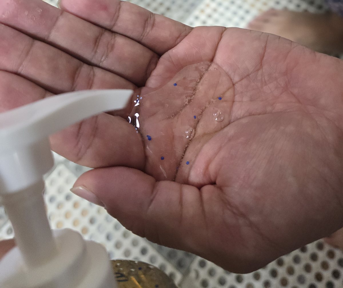 펌프에서 손바닥에 짠 샴푸와 그 안의 파란 캡슐 알갱이